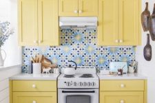 a tiny yellow kitchen with shaker cabinets, a bold blue patterned tile backsplash is a cheerful and fun space to be in