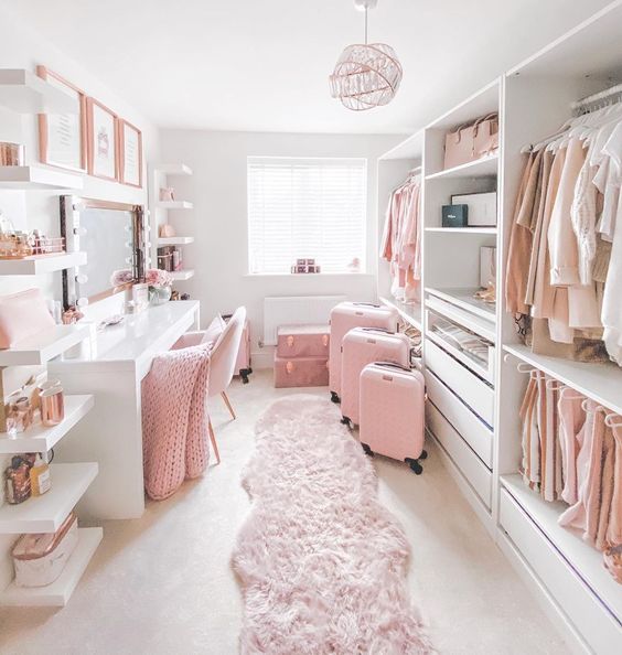 a very girlish closed with open storage units and drawers, with open selves, a white vanity with a large mirror and pink touches