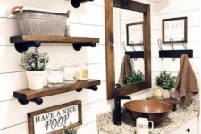 a white barn bathroom with wood plank walls, a stone countertop, wooden shelves, a metal sink and vintage lamps over it