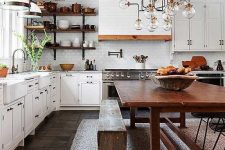 a white country kitchen with shaker style cabinets and a tiled hood, a reclaimed wood ceiling with beams and a shabby chic dining set