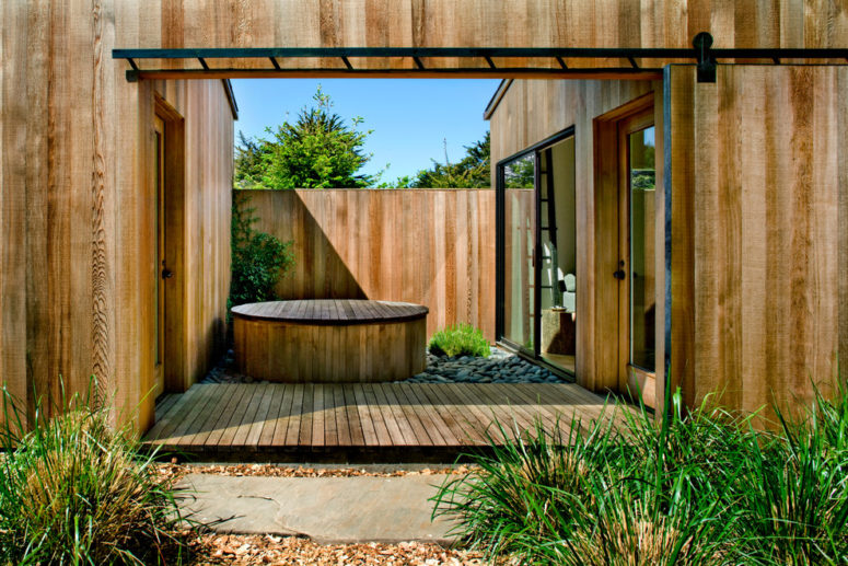 a hot tub with a cover that matches an overall terrace's decor is a great way to create a stylish backyard area (Turnbull Griffin Haesloop)