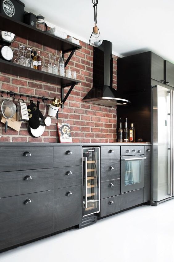 a bold kitchen with dark wooden cabinets and red brick walls for a catchy look with a vintage feel