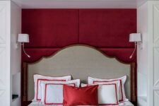 a bold red and white bedroom with a storage unit in white, a bed integrated into a niche, a red bench and red bedding