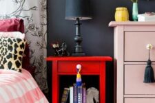 a bold red nightstand contrasts a blush dresser and color and interest to the space