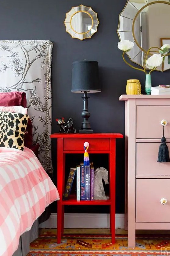 a bold red nightstand contrasts a blush dresser and color and interest to the space