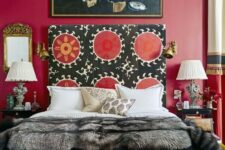 a bright and catchy bedroom with a bold red accent wall, a bed with a unique patterned headboard, refined nightstands and lamps