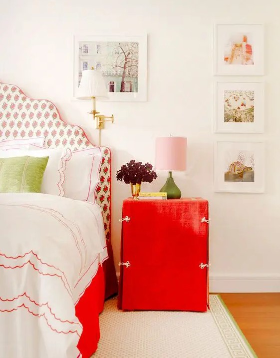 a bright red nightstand and a red floral print upholstered bed for a cute touch