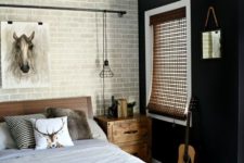 a chic monochromatic bedroom with a fake grey brick wall, a black statement one and animal-inspired decor