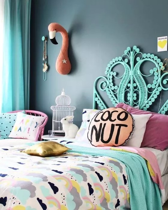 a colorful bedroom with a black accent wall, a hot pink chair, a turquoise bed, bright printed bedding, a flamingo head on the wall
