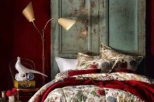 a deep red statement wall and a matching bedspread add color and interest to the room