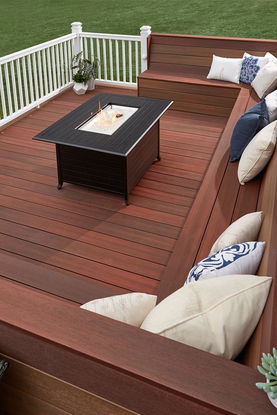 a laconic modern deck with a built-in bench, a coffee table with a drink cooler in the center and sculptural planters