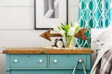a lovely vintage rustic dresser in turquoise, with a wooden countertop, a turquoise printed curtain and an aqua tote