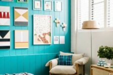 a mid-century modern bedroom with a turquoise accent wall with bright art, a bed with printed bedding, a wooden bench and a rattan credenza