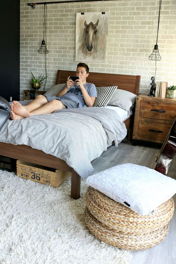 a neutral rustic and vintage bedroom with a faux brick wall, rich stained furniture and jute ottomans looks awesome