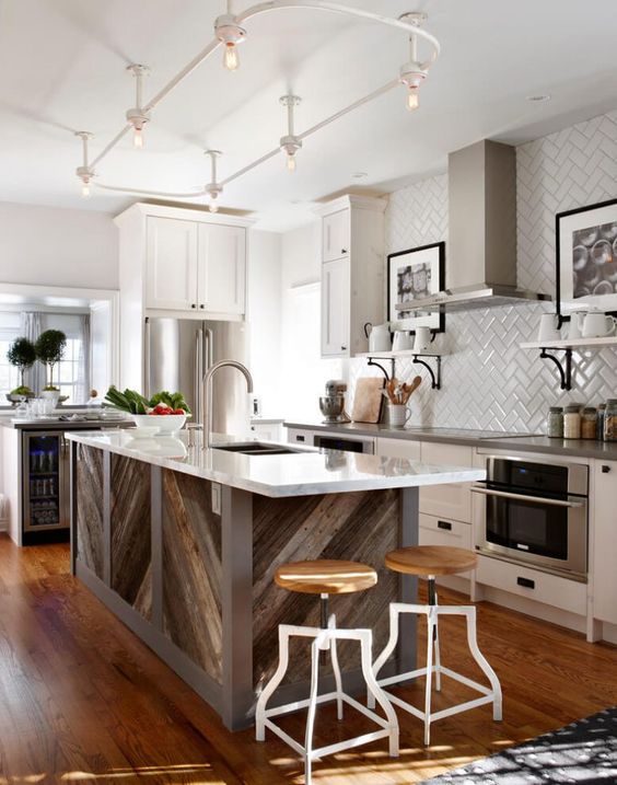 a pallet wood chevron clad kitchen island with a white countertop stands out in this neutral kitchen and adds a rustic feel