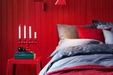 a red wooden plank wall, a matching sconce and a nigthstand create a super colorful space