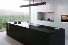 a sleek black kitchen island seems a monolith and contrasts the white kitchen and makes and statement here