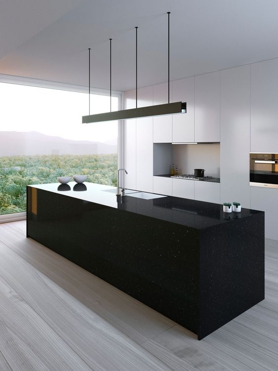 a sleek black kitchen island seems a monolith and contrasts the white kitchen and makes and statement here