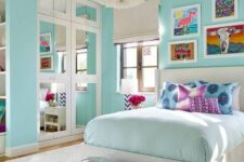 a turquoise teen girl bedroom with a built-in closet with mirror doors, a neutral bed with colorful bedding, silver poufs and a fluffy pendant lamp