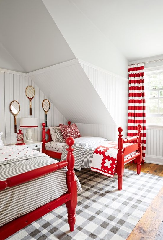 a vintage attic guest bedroom with vintage red beds, striped cutrains, a table lamp and a lantern in red