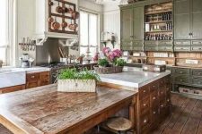 a vintage green kitchen with shaker cabinets, an oversized stained kitchen island with an additional table and stools