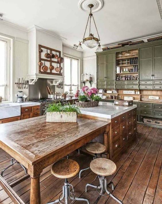 a vintage green kitchen with shaker cabinets, an oversized stained kitchen island with an additional table and stools