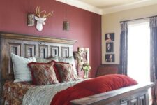 a vintage rustic bedroom with a burgundy statement wall, heavy wooden furniture, pendant lamps, vintage refined bedding and printed textiles