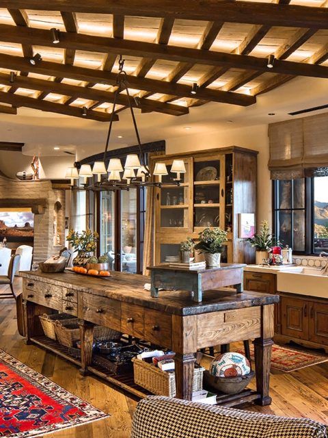 a vintage rustic kitchen with shaker style cabinets, a wooden beam ceiling, an oversized stained kitchen island with storage compartments