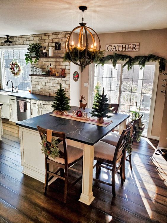 a white farmhouse kitchen with shaker style cabinets, black stone countertops, white tiles, a vintage kitchen island with a marble countertop