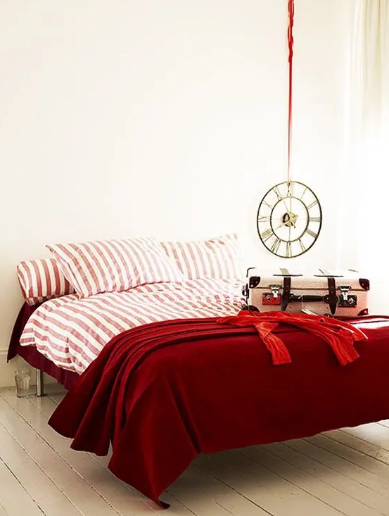 deep red and pink and white striped bedding set spruces up a neutral bedroom and raises the mood