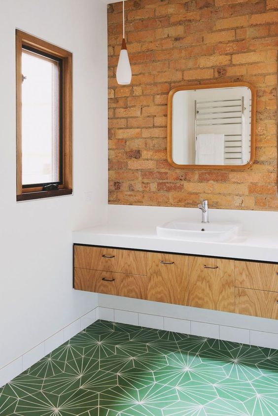 red brick paired with green geometric tiles, a light-colored vanity and a white countertop look chic and bold
