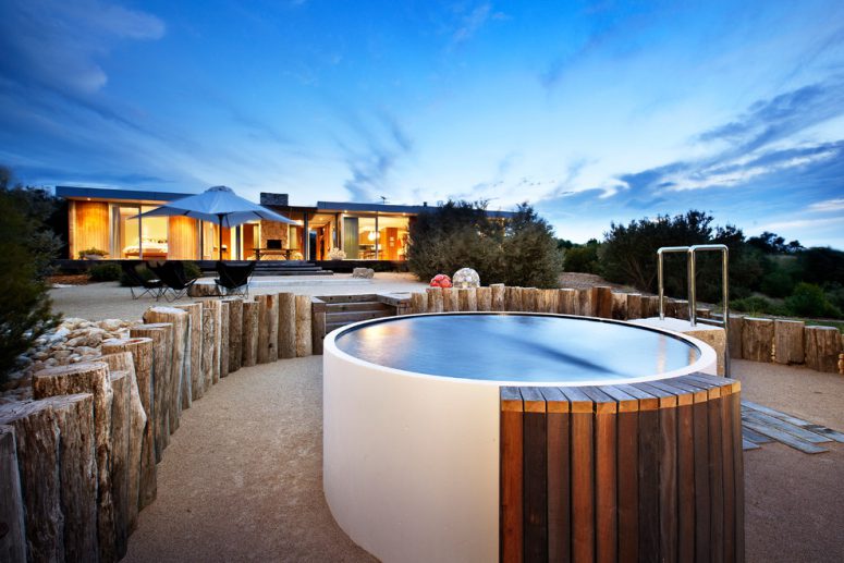 small contemporary round backyard hot tub design that look great surrounded by weathered tree trunks