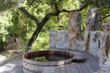 a hot tub with a stone privacy screen