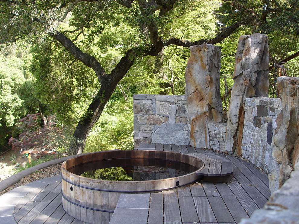 a hot tub with a stone privacy screen