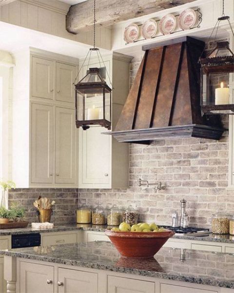 white cabinets, whitewashed bricks, an aged metal hood make up a chic and elegant rustic kitchen