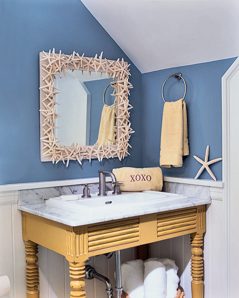 a fun and whimsy sink space with a vintage wooden vanity, a starfish clad mirror and simple towels  (Marcus Gleysteen Architects)