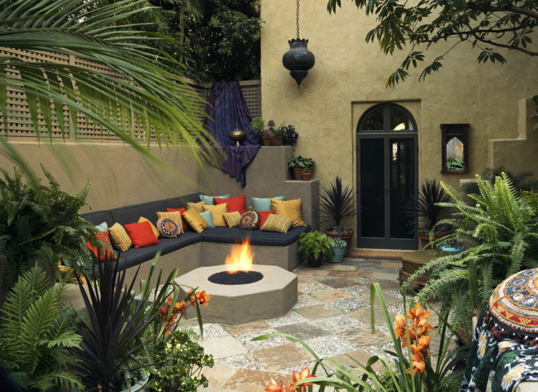 a colorful Moroccan patio with a fire pit, an L-shaped sofa with bright pillows, Moroccan lanterns over the space (Tommy Chambers Interiors, Inc.)