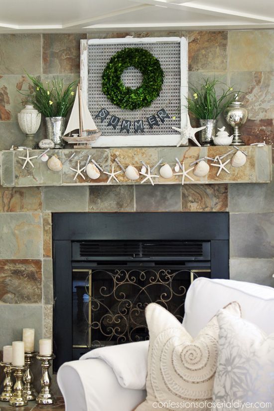 a beach mantel with a starfish and seashell garland, a boat, a starfish, some blooms and greenery