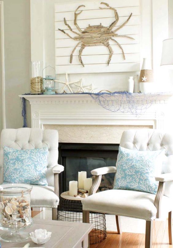 a beach mantel with bleu fishing net, starfish, a wrapped vase, a lantern and a driftwood crab artwork