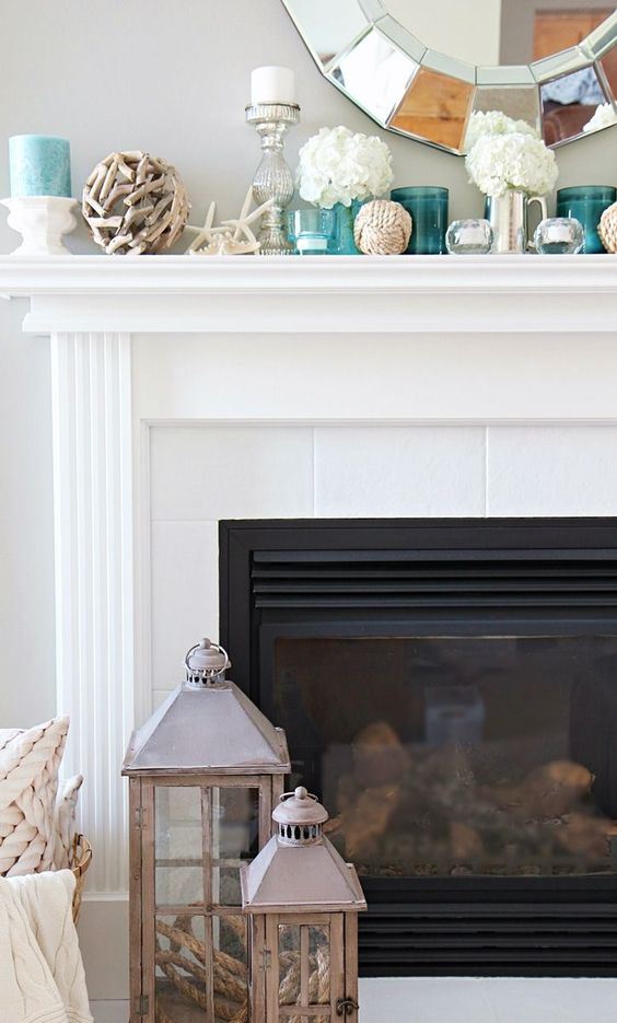 a beachy mantel with starfish, a driftwood ball, candles, white hydrangeas, turquoise candles and turquoise candle holders