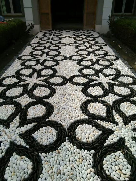 a bold black and white pebble garden path with a catchy pattern is a mosaic decoration