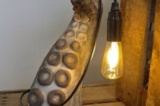 a catchy and cool table lamp of a tentacle and a bulb is a unique and bold solution to go for
