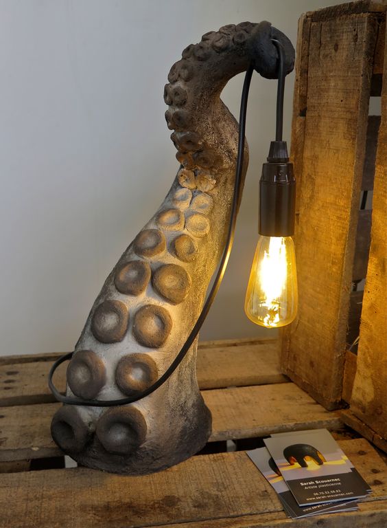 a catchy and cool table lamp of a tentacle and a bulb is a unique and bold solution to go for
