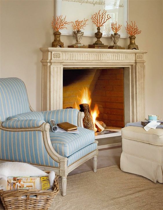 a classic beach mantel with corals on vintage stand and vintage urns is a lovely and simple idea