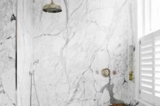 a contemporary bathroom with white marble, sleek wood and vintage hardware for a bright and chic look