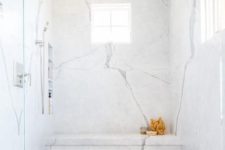 a walk-in shower clad in marble