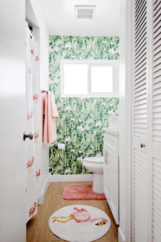 a fun and playful tropical bathroom with an accent wall, a pink and flamingo rug, a flamingo curtain and pink towels