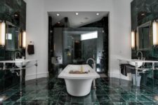 a gorgeously elegant bathroom with green marble tiles on the walls and floor and in the shower
