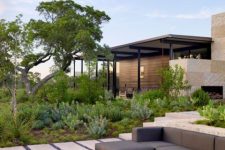 a modern and chic outdoor space with a grey sectional and a metal box as a fire bowl is a lovely and cool space