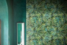 a moody tropical bathroom with a statement mural, a green plaster tub and grene plaster walls